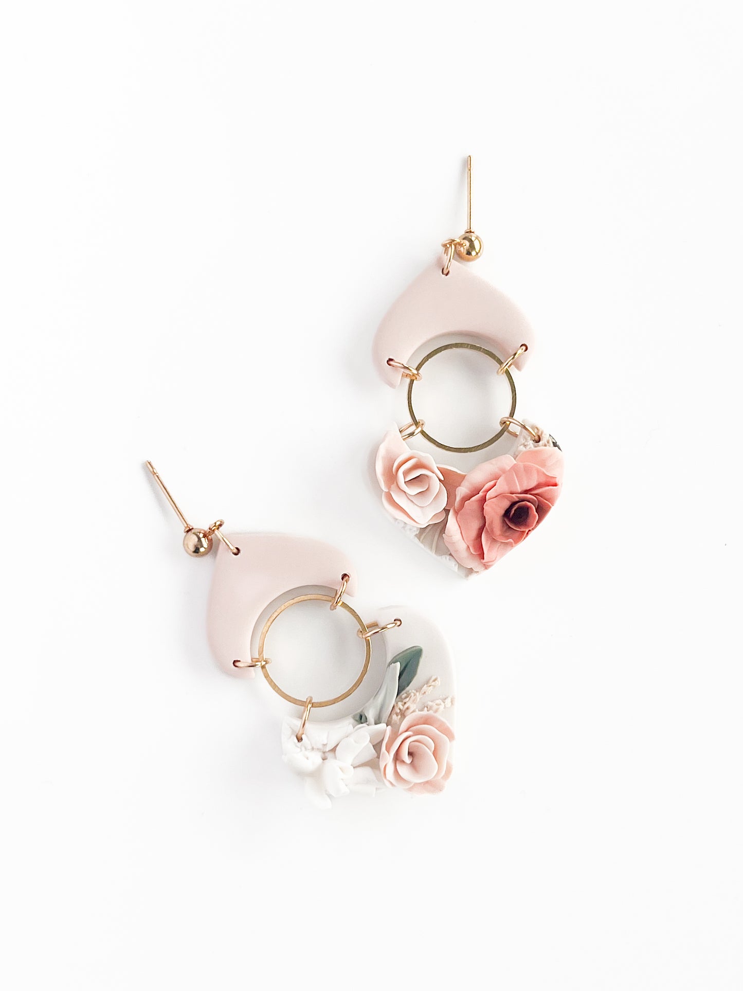 Meet "Sarah" by Agave Designs: made-to-order dangle earrings featuring gold hoops with pale pink geometric shapes and delicate clay flowers in blush and dusty rose, set against a white background.