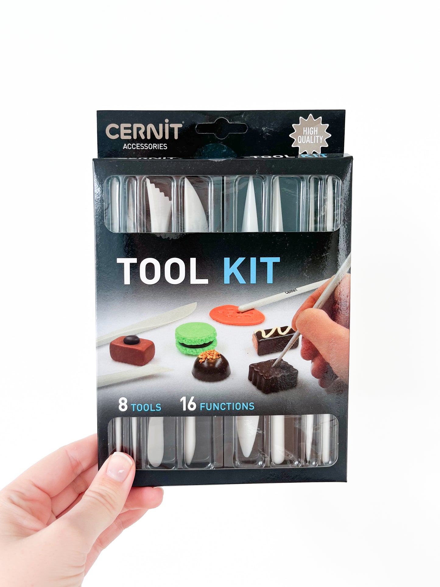 A hand holds a packaged Cernit Tool Kit from Agave Designs against a white background. The black box displays text "8 Tools, 16 Functions" and shows images of the precision modeling tools being used on small pieces of colored clay or fondant. "HIGH QUALITY" is printed at the top right corner.