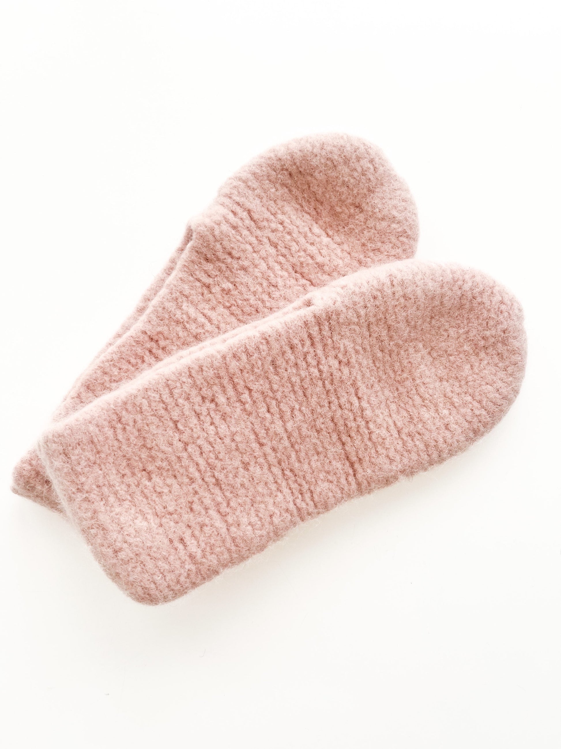 A pair of cozy, soft Dusty Pink Wool slippers by Agave Designs is displayed against a plain white background. The slippers are plush and textured, suggesting warmth and comfort.