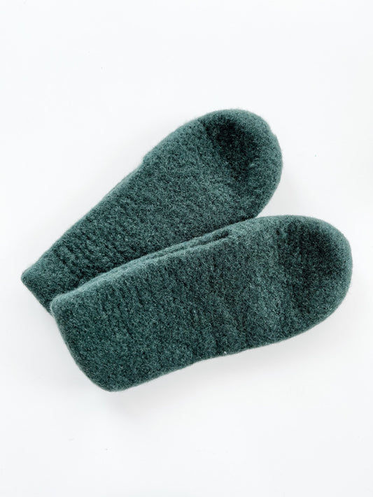 A pair of Dark Sea Green Wool Slippers is laid side-by-side on a white background. The texture appears soft and plush, potentially crafted from high-quality wool by Agave Designs, providing a sense of warmth and comfort. Remember to hand wash these slippers to maintain their luxurious feel.